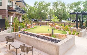 a courtyard with a miniature golf course and tables and chairs